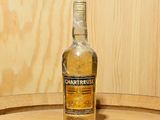 une bouteille d'alcool posée sur un tonneau en bois