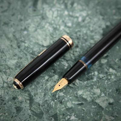 deux stylos à plume posés l'un à côté de l'autre sur une table