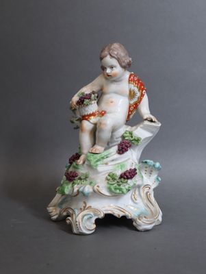 une figurine représentant un garçon tenant un panier de fleurs
