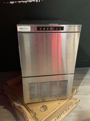 an image of a stainless steel ice maker sitting on top of a cardboard box