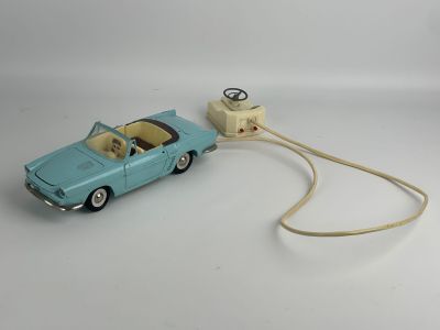 a toy car connected to a charger on a white surface