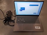 a laptop computer sitting on a table with a charger attached to it
