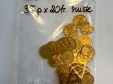 un sac de pièces d'or posé sur une table blanche