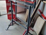 une photo d'un établi dans un garage, avec des outils posés par terre