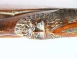 a close up of a rifle with a lion head on it