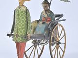 a figurine of a man and a woman riding in a carriage