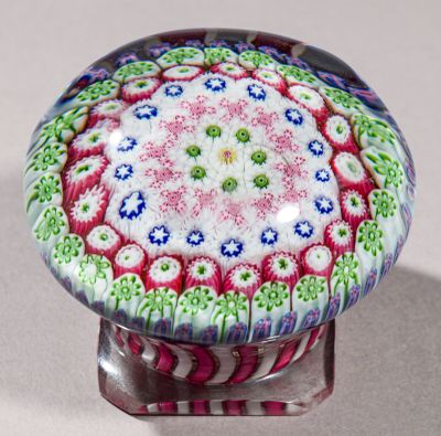 un bouton en verre coloré orné d'un motif floral