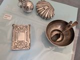 une table sur laquelle se trouvent des objets en argent et un livre