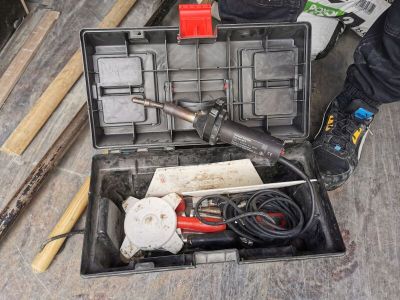 une boîte à outils contenant des outils, posée sur le sol
