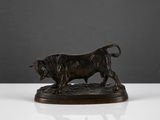 une figurine en bronze représentant un taureau sur un fond blanc