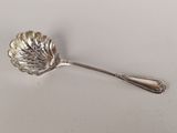 un gros plan d'une cuillère en argent ornée d'une feuille