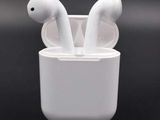 une paire d'AirPods posée dans une tasse sur une surface noire