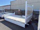 une benne de camion blanche garée au milieu d'un parking