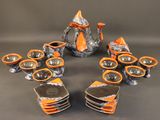 several pieces of orange and black pottery sitting on top of a table