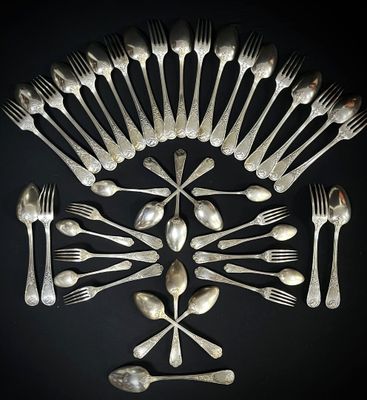 un grand nombre de cuillères et de fourchettes en argent disposées en cercle
