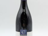 la bouteille de vin est posée sur une surface blanche