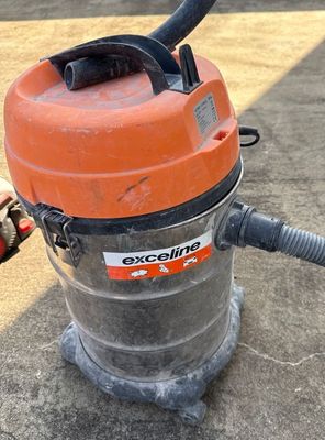 an orange and black vacuum cleaner sitting on top of a cement floor