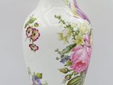 a white vase with a floral design on it