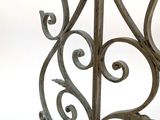 a close up of a metal gate with a bird on top of it