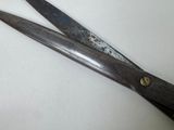 a pair of scissors sitting on a white surface