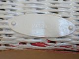 a close up of a white basket with a name plate on it