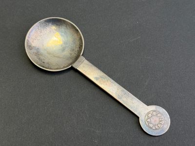 une cuillère avec un manche en métal posée sur une table