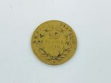 a gold coin on a white surface with a white background