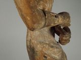a wooden statue of a woman holding a banana