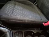the interior of a car with a black seat and a red button