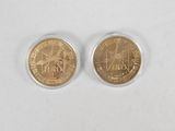 two gold coins with the image of a man and woman on them