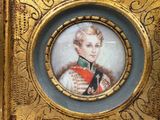 a gold frame with a picture of a man in a military uniform