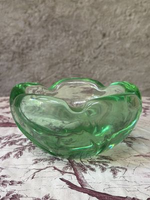 a green glass bowl sitting on top of a table