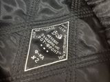 the back of a black jacket with a white patch on it