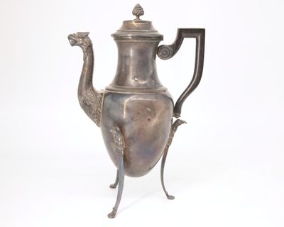 une théière en argent ornée d'un oiseau