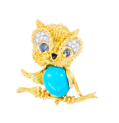 une photo d'une broche en forme de chouette en or ornée d'une pierre turquoise