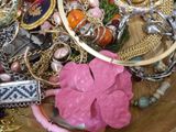 a wooden bowl filled with assorted jewelry on a table