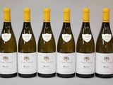 six bouteilles de vin sont alignées sur une table