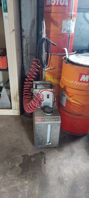 une machine posée par terre à côté de quelques fûts