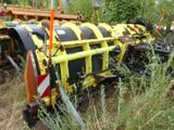 a yellow and black tractor that is parked in the grass