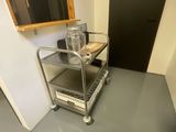 a metal cart with a bottle on it in the corner of a room