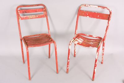 two red chairs sitting next to each other on a white surface