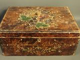 an old wooden box with a floral design on the lid
