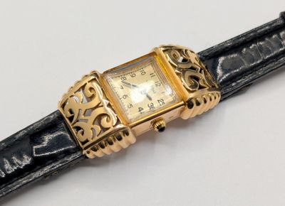 a watch that is sitting on a black leather strap