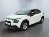 Une Citroën blanche est garée dans une pièce blanche