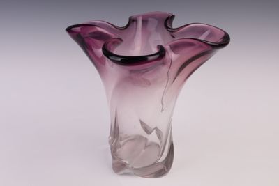 un vase en verre violet posé sur une table
