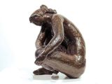 a statue of a man sitting on a white surface