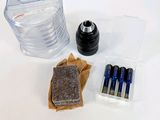 le contenu d'une bouteille d'eau, des piles et d'autres objets sont disposés sur une surface blanche