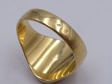 a close up of a gold ring on a white surface