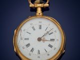 a gold pocket watch with roman numerals on the face