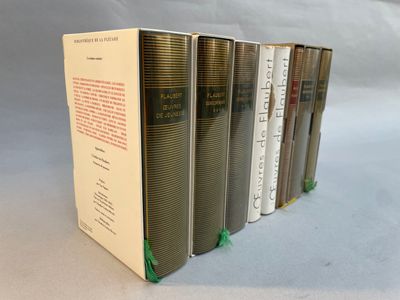 six books are lined up in a row on a white surface